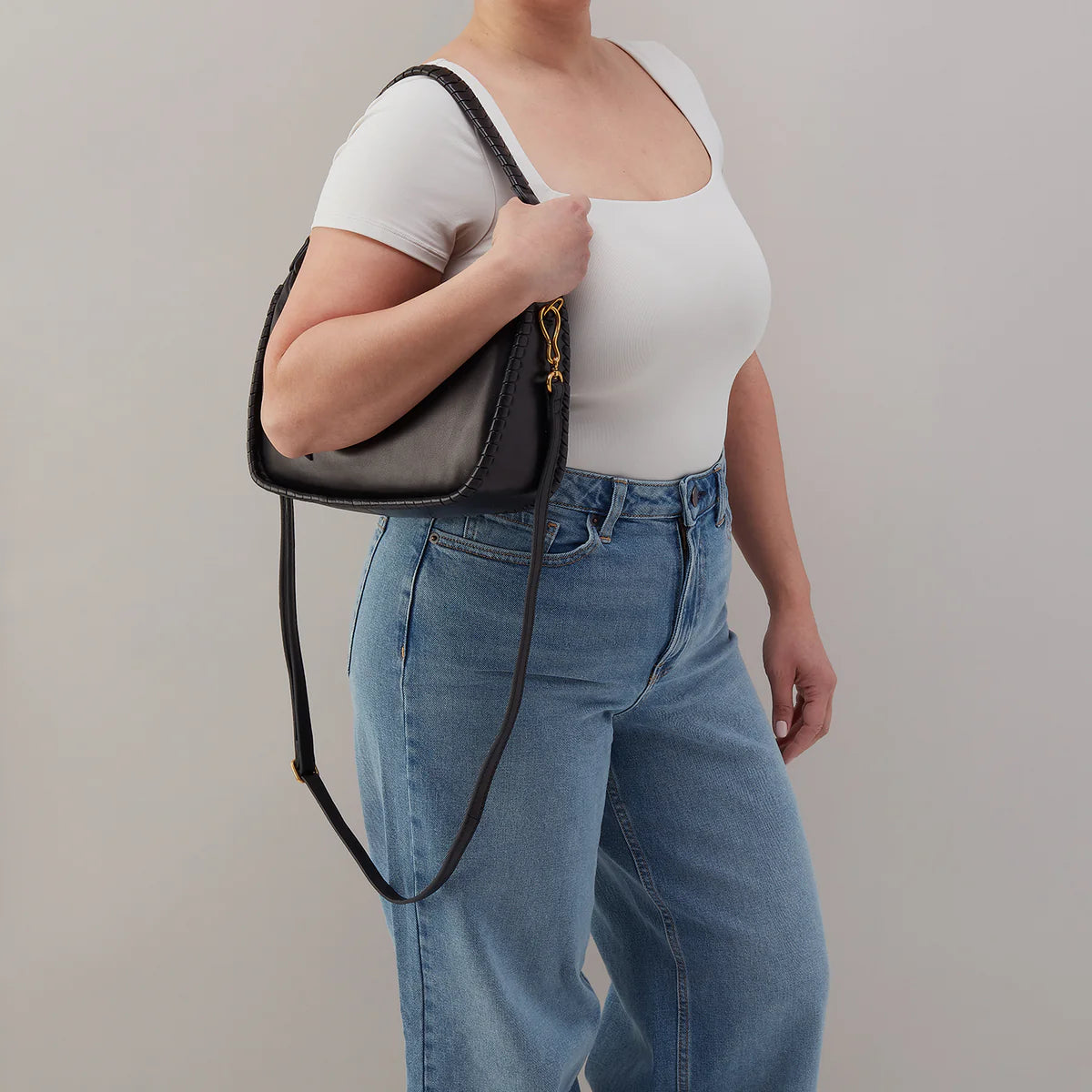 a person wearing the mia bag in black