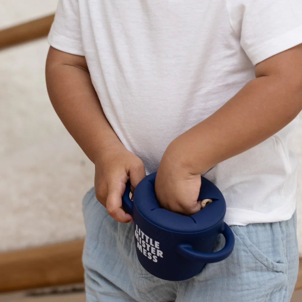 child's hand getting snacks from happy snacker.