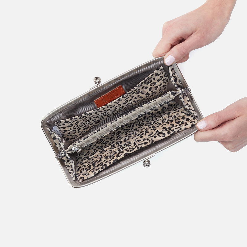 hands holding open leopard Cora Large Frame Wallet showing interior.