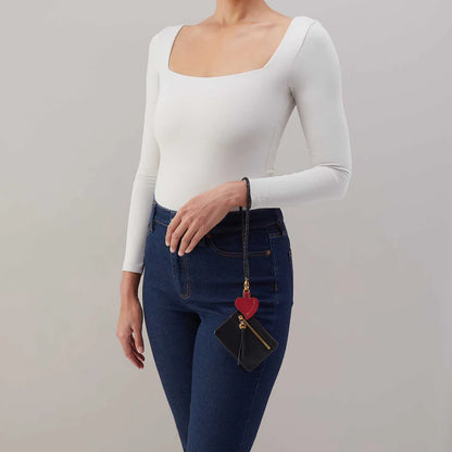 person wearing jeans and a white top with black Lasso Phone Wristlet on their wrist