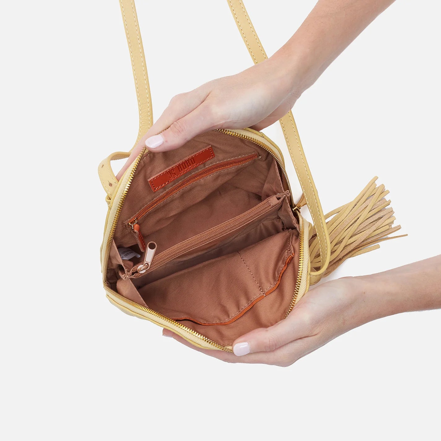hands holding open flax Nash Crossbody showing interior.
