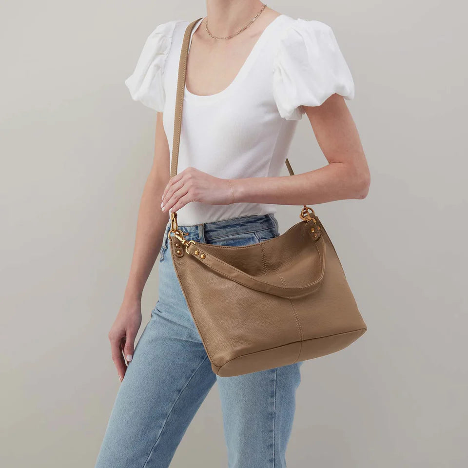 person wearing jeans and a white top with cedar sagebrush Pier Crossbody Shoulder Bag over their shoulder