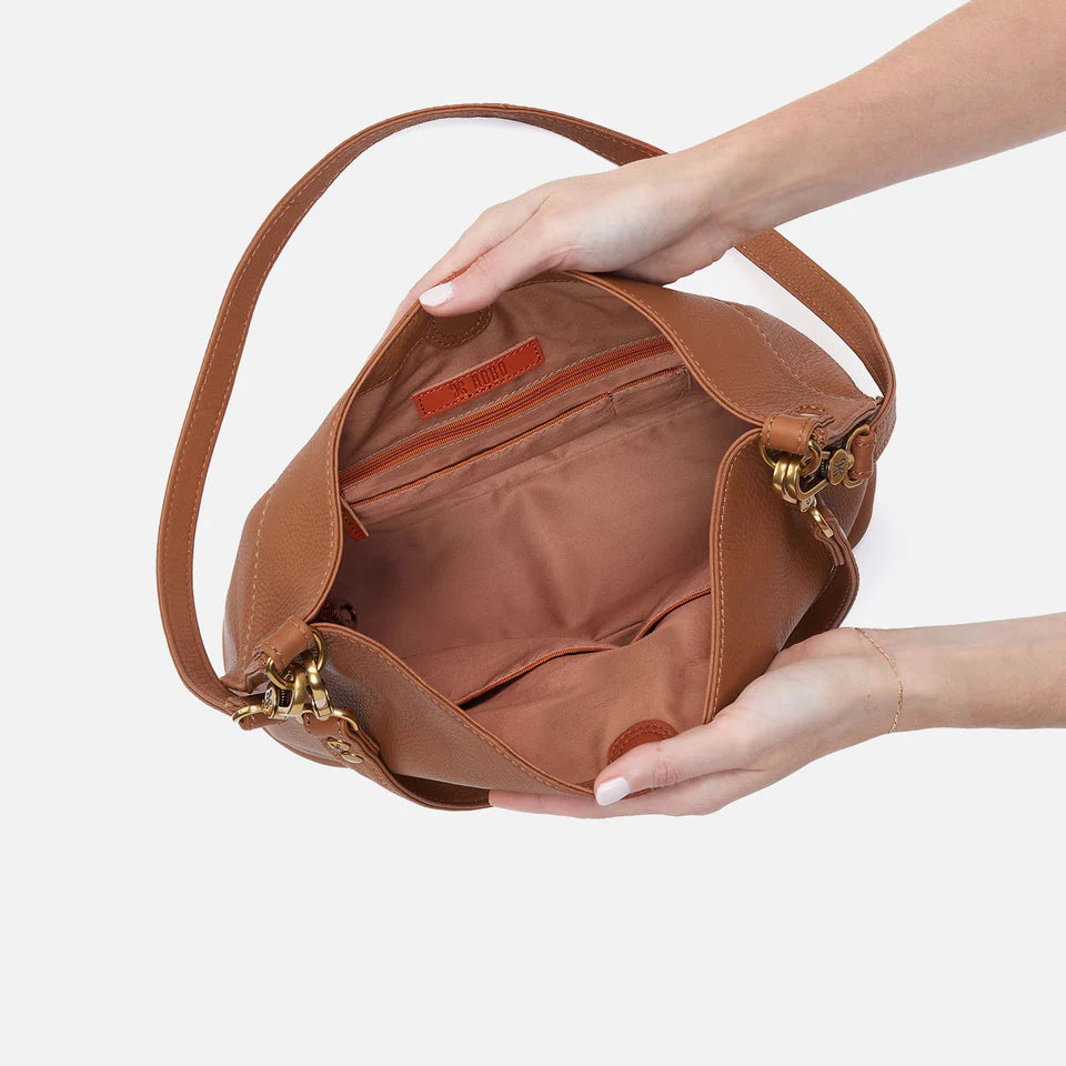 hands holding open warm honey Pier Crossbody Shoulder Bag showing interior