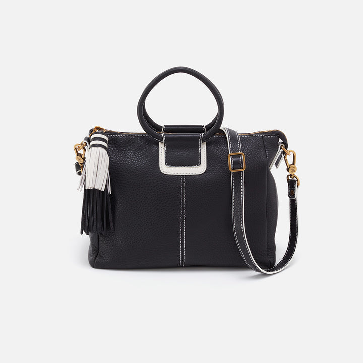 black medium sheiela bag with white accents and a black and white chunky tassel zipper pull.