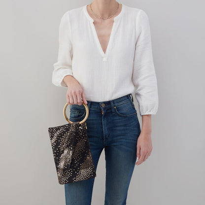 person wearing jeans and a white blouse holding shooting stars ring clutch.