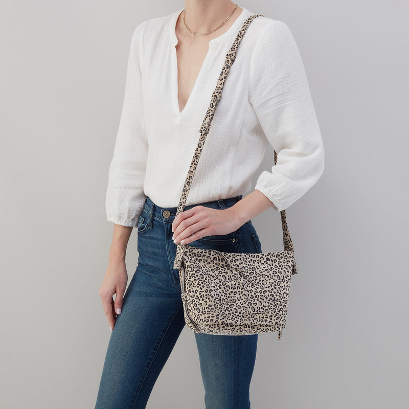 person wearing jeans and a white top with the leopard Bonita Crossbody on their shoulder.