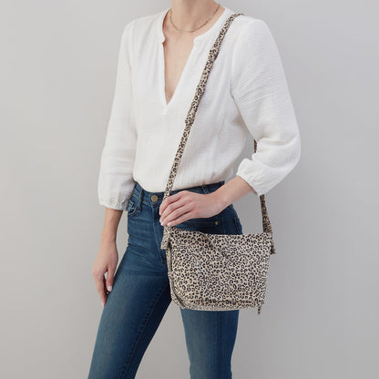 person wearing jeans and a white top with the leopard Bonita Crossbody on their shoulder.