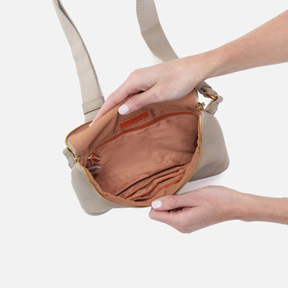 hands holding open taupe fern bag showing interior.