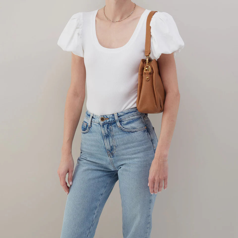 person wearing jeans and a white top with warm honey Starr Convertible Shoulder Bag over their shoulder