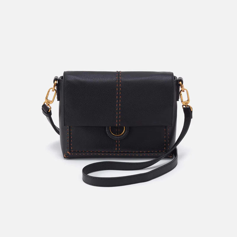black Austin Flap Crossbody with strap draped around it