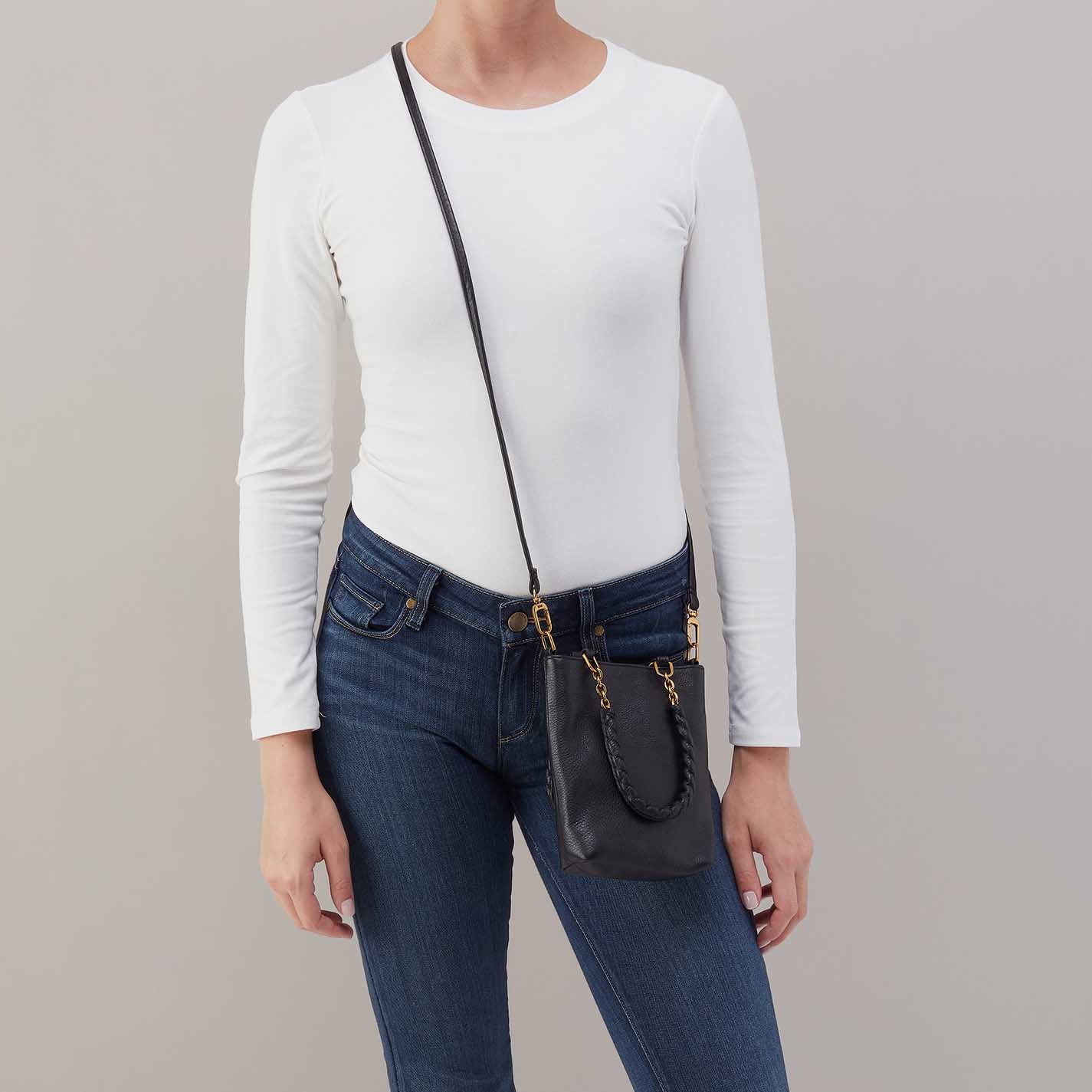 Person wearing jeans and a white top
with black Tennessee Mini Bag over their shoulder

