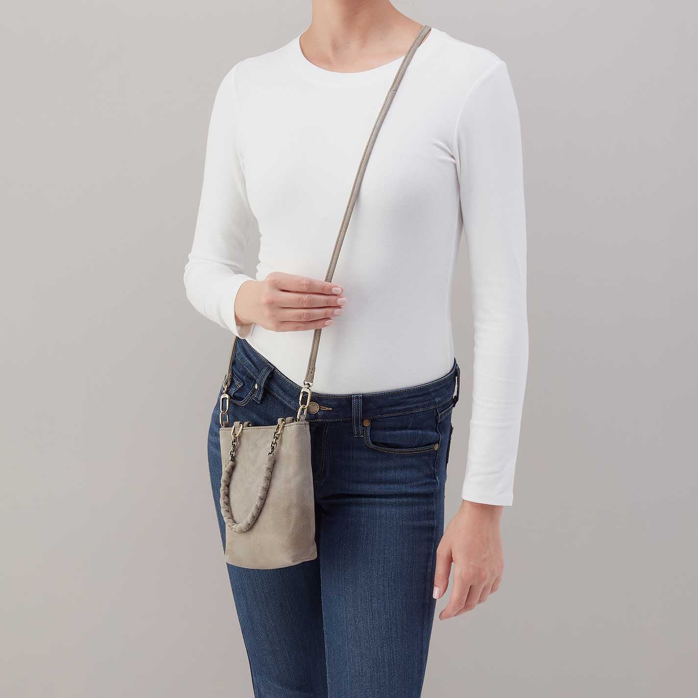 Person wearing jeans and a white top with golden granite Tennessee mini bag over their shoulder