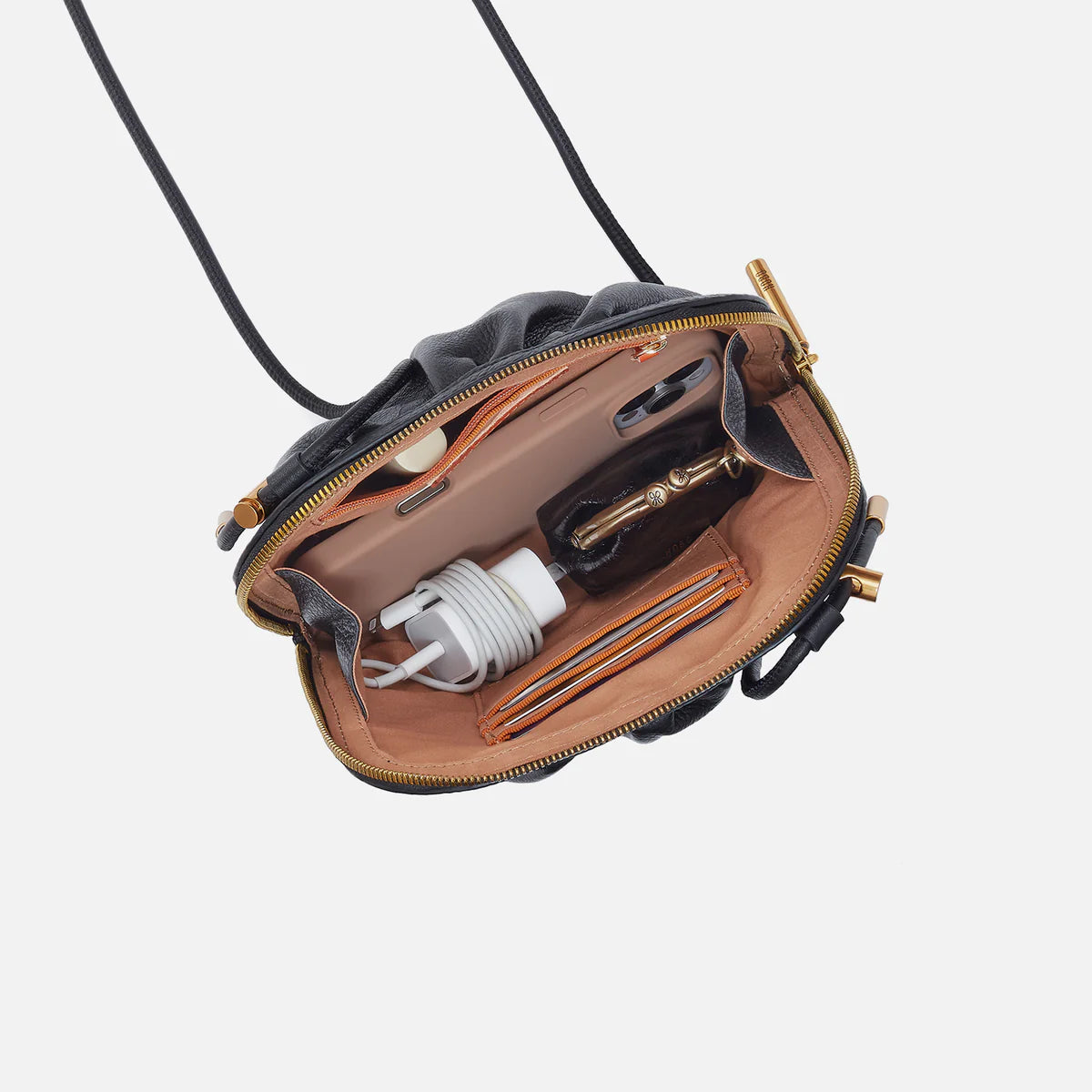 Isabelle Crossbody in the color black open to show stuff inside
