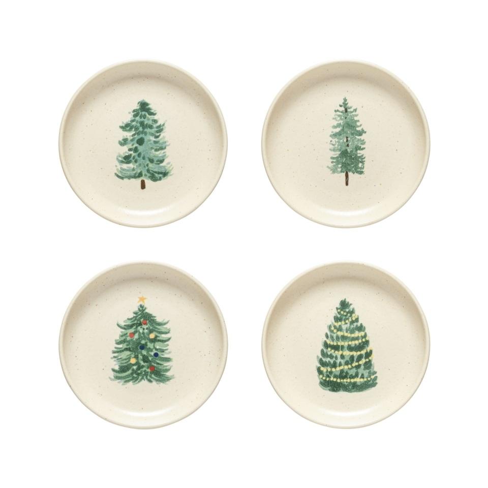 4 off-white small plates with assorted tree designs painted on them.