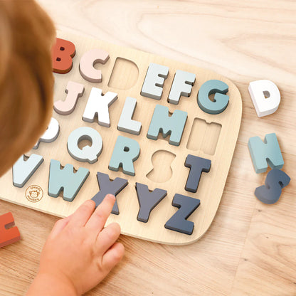 top view of child playing with alphabet puzzle.