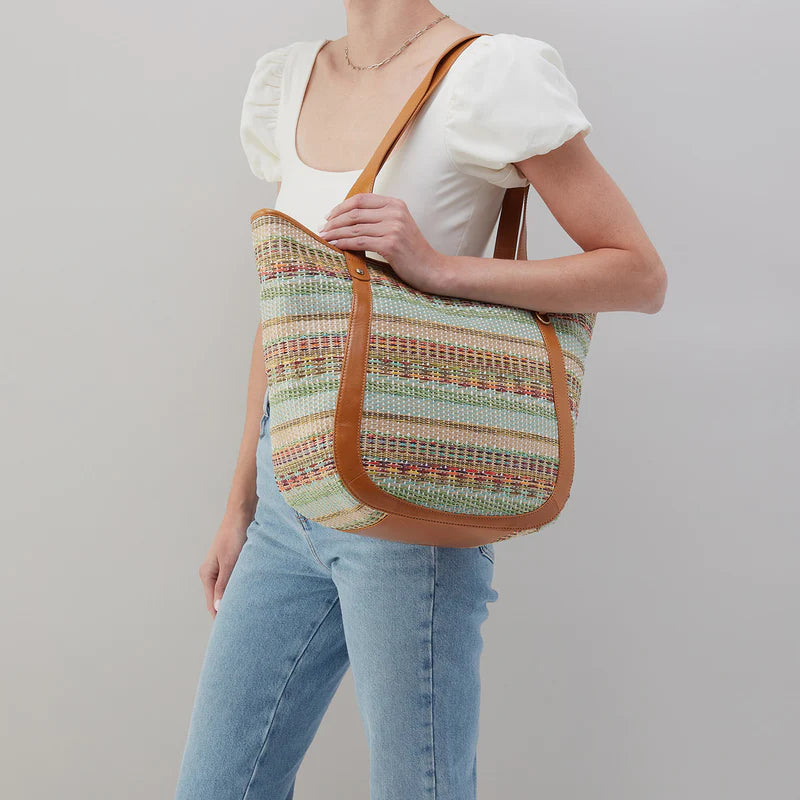 person wearing jeans and a white top with the sonder bag on their shoulder.