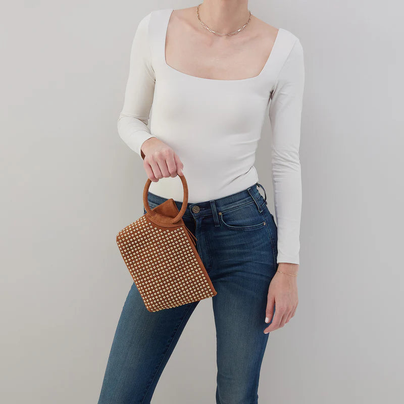 person wearing jeans and a white top holding Maggie Clutch.