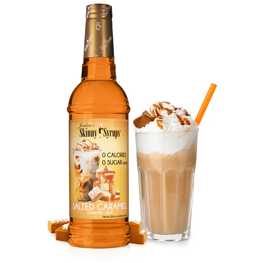 bottle of salted caramel skinny syrup set next to a frozen coffee beveage with whipped topping.