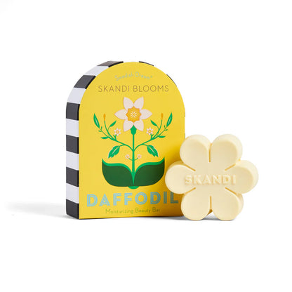 flower shaped bar of soap set next to its yellow box packaging