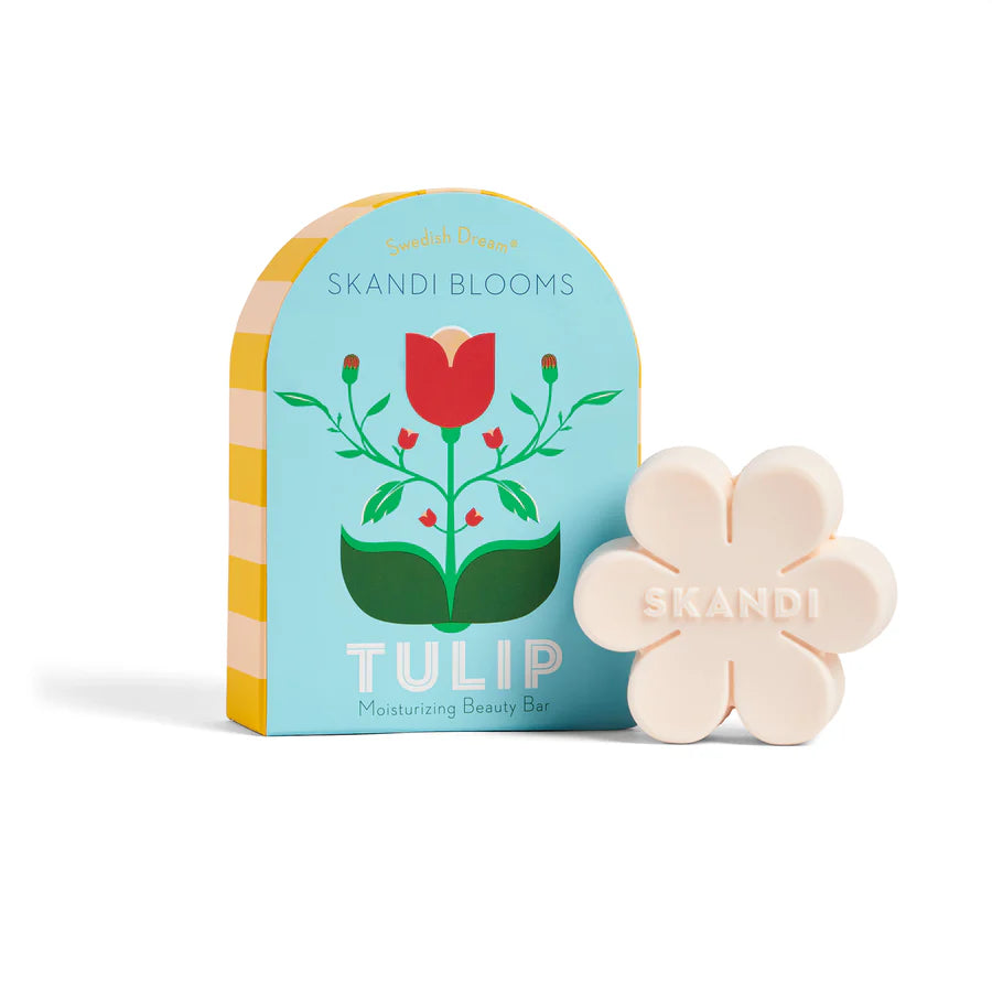 Flower shaped bar of soap set next to a blue box packaging.