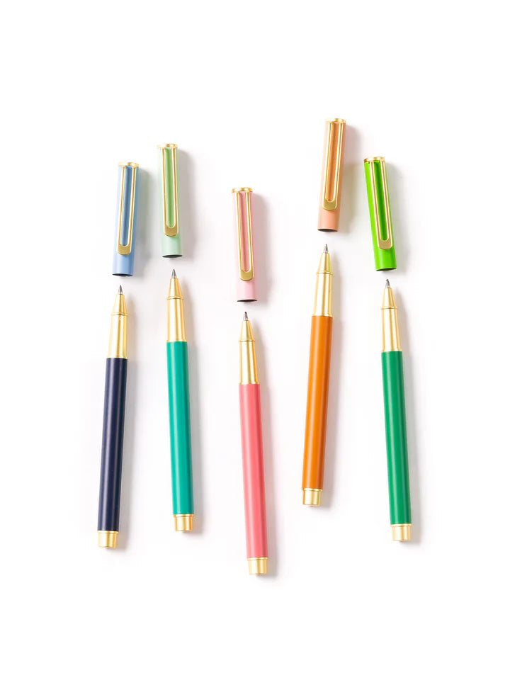 all 5 colors of so darling pens arranged on a white background with their lids off above them.