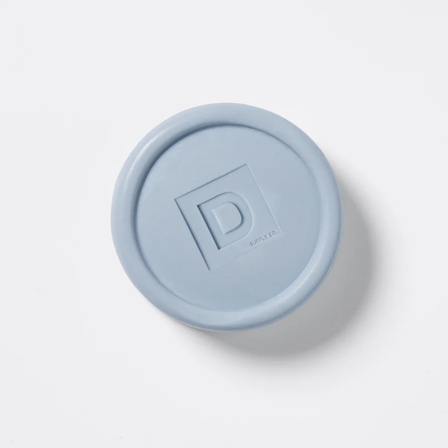 round Blue soap puck bar with a "D"  logo on a white background
