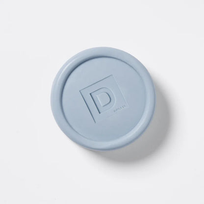 round Blue soap puck bar with a "D"  logo on a white background
