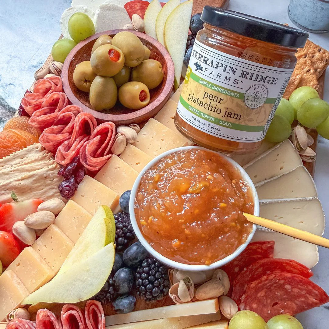 Charcuterie board with various meats, cheeses, fruits, and a jar of Terrapin Ridge Farms jam.