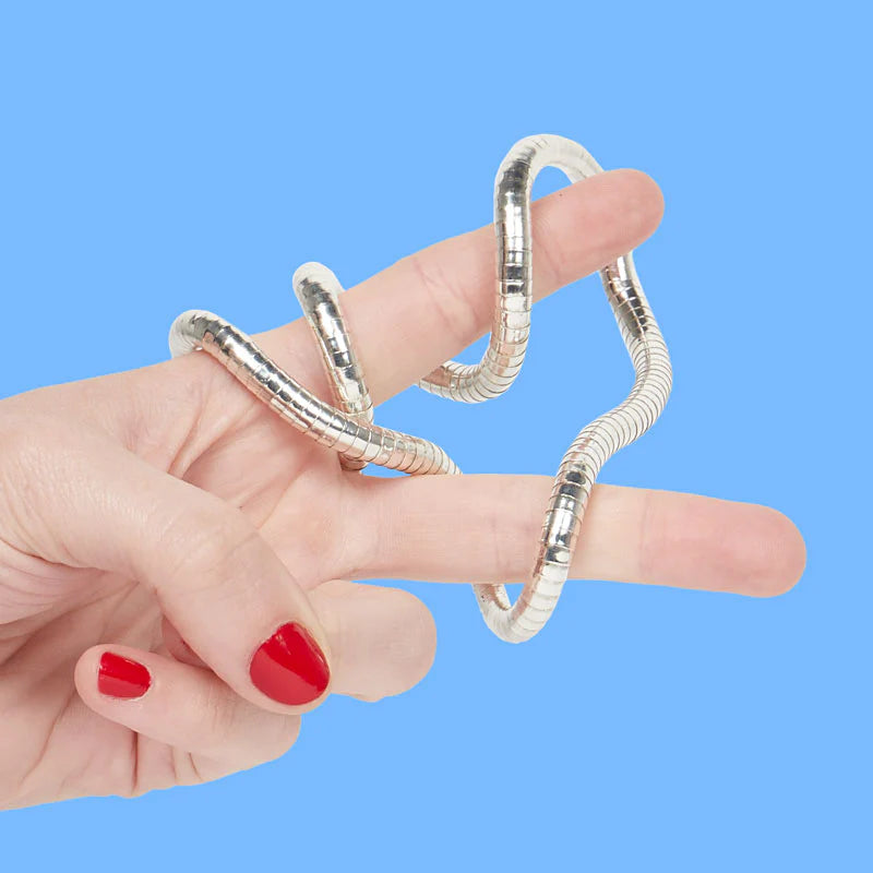 Silver spiral fidget on a persons fingers against a blue background