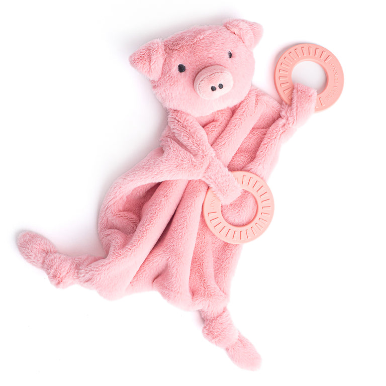 pink pig buddy teether with teething ring draped across it.
