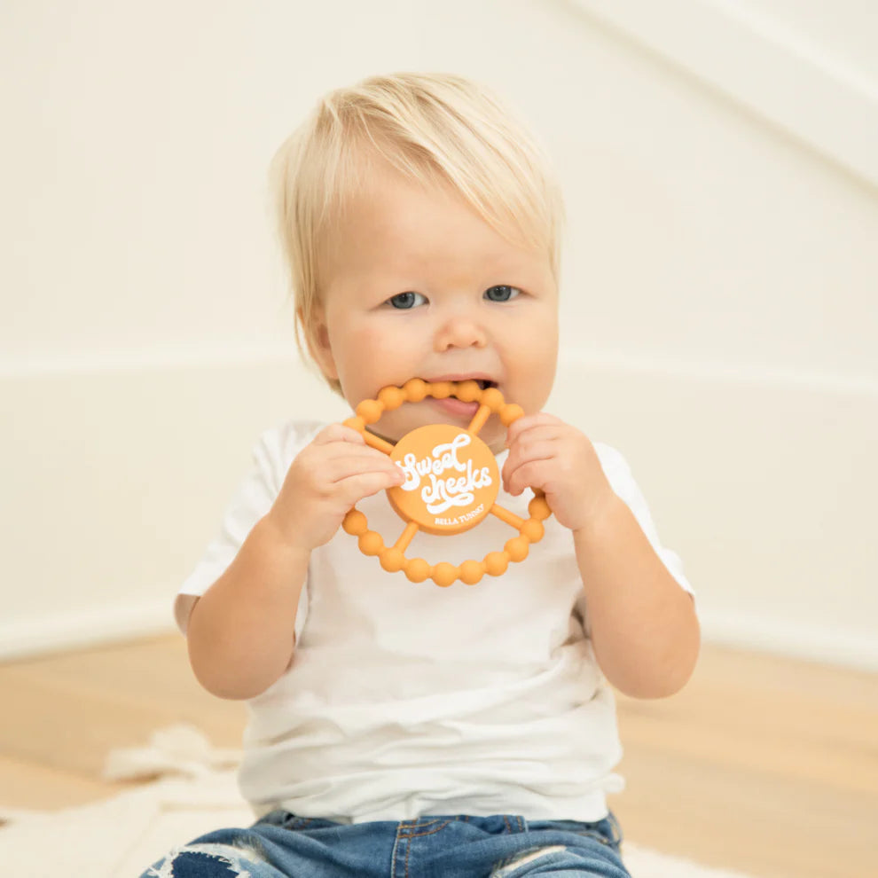 baby chewing on sweet cheeks teether.