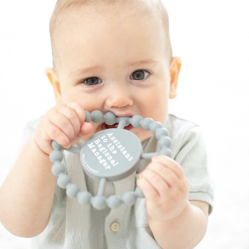 baby chewing on "assistant" teether.