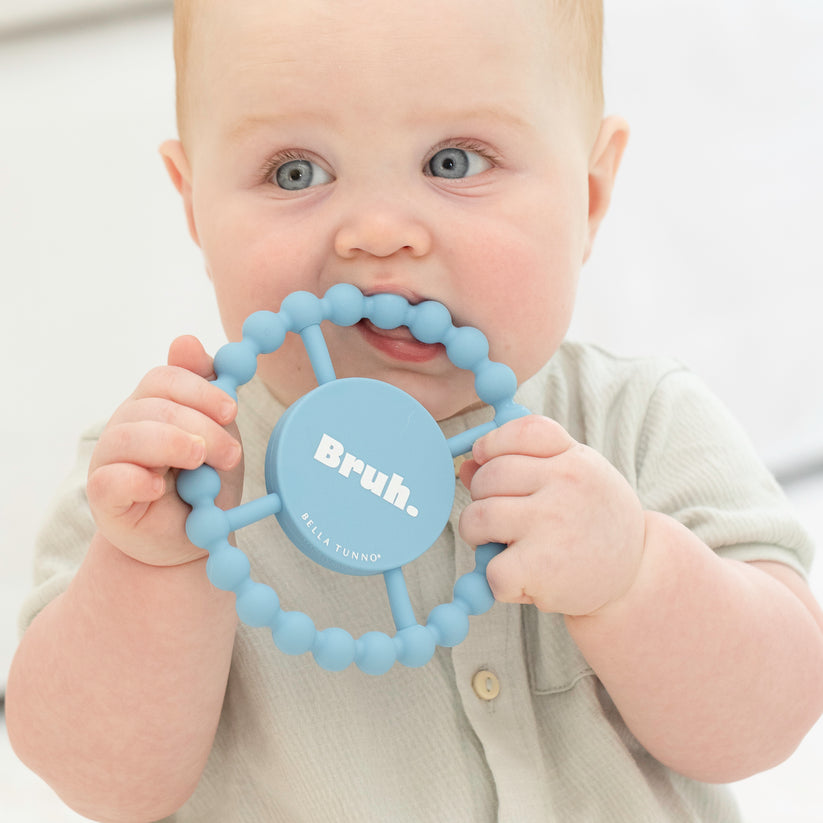 baby chewing on "bruh" teether.