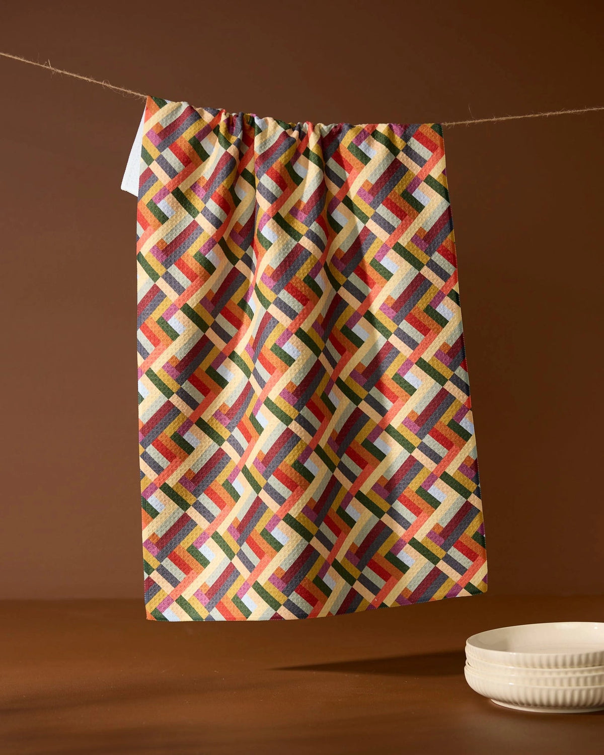 Vivid Cascade Tea Towel hanging on a line on a brown background