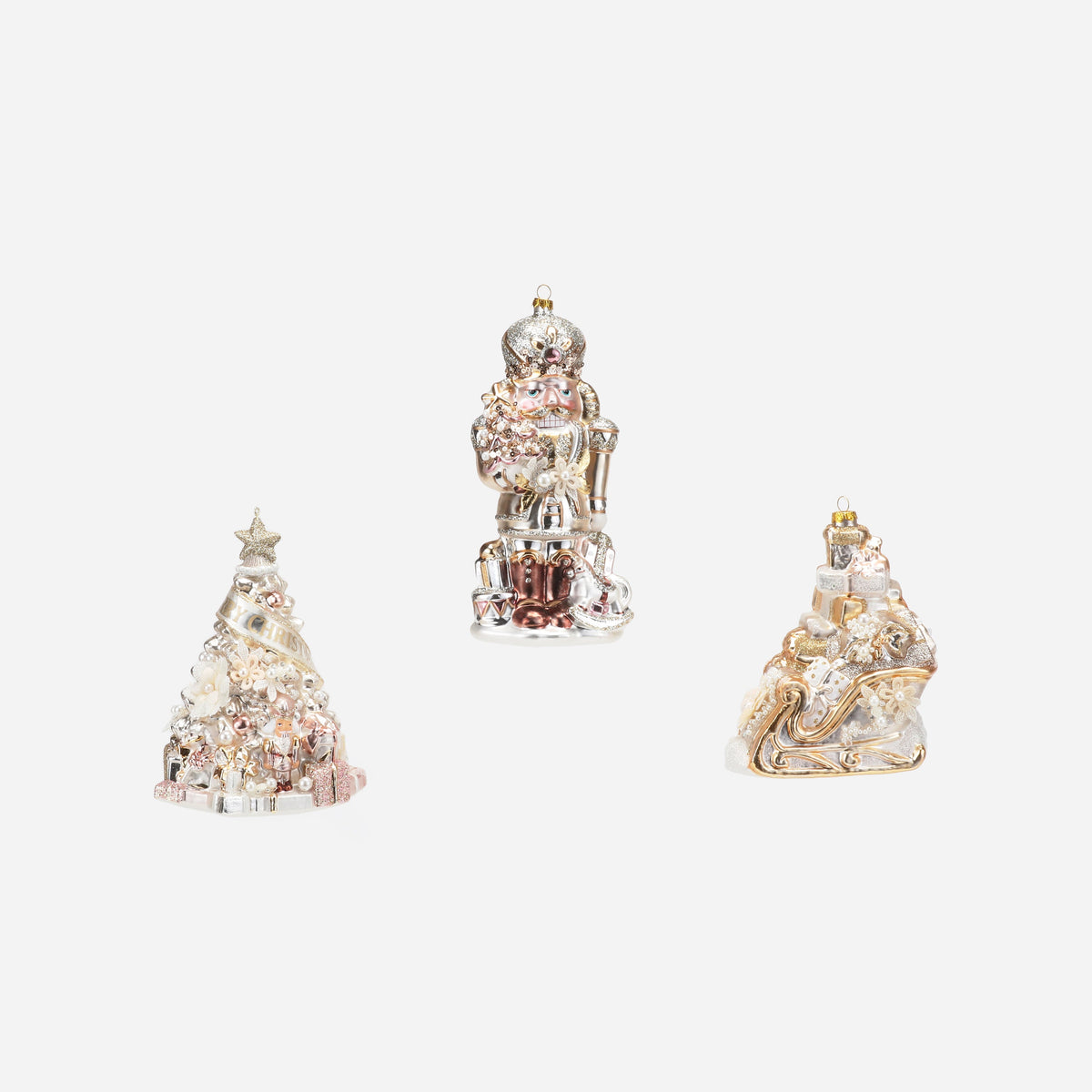 tree ornament, nutcracker ornament, and sleigh ornament on a white background