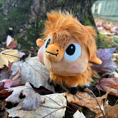 front angled view of Buffalo Fluffalo Puffalo Plush Toy on a bed of fall leaves