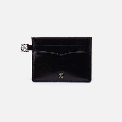 Black leather cardholder with a gold clasp on a light gray background