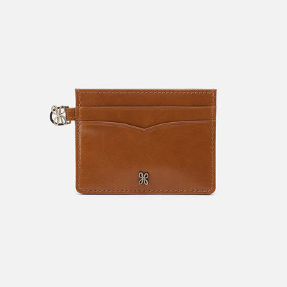 Brown leather cardholder with a gold clasp on a light gray background