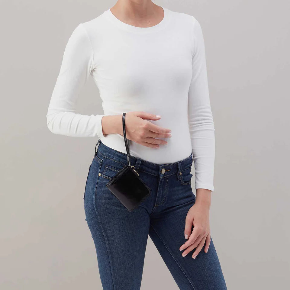 person wearing jeans and a white top carrying black Coin Wristlet Wallet