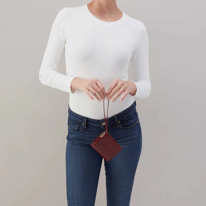 person wearing jeans and white top holding aniline gloss leather Coin Wristlet Wallet