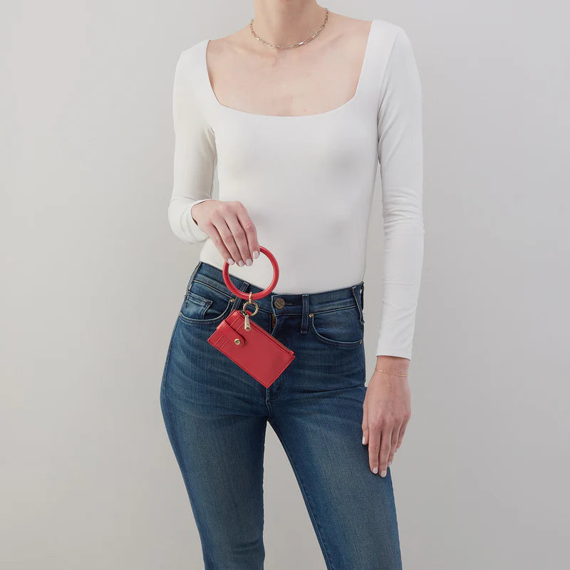 person wearing jeans and a white top holding hibiscus Ring Credit Card Wristlet.