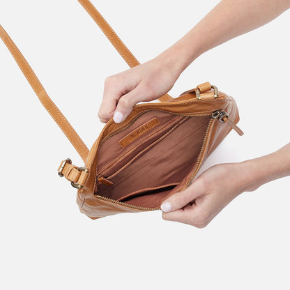 hands holding open natural Cambel Crossbody showing interior of bag.