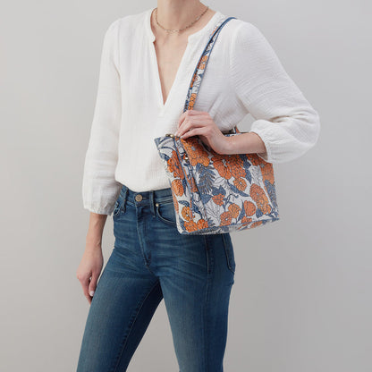 person wearing jeans and a white top with orange blossom Haven Tote on their shoulder.