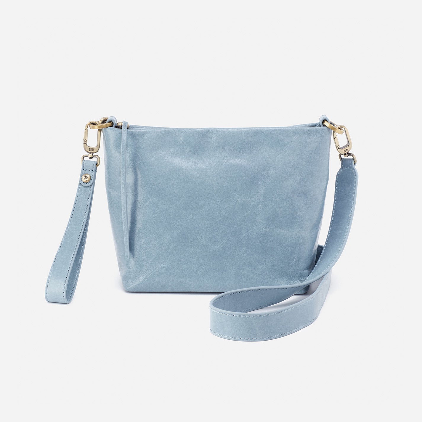 cornflower Ashe Crossbody with strap and wristlet draped around it on a white background.