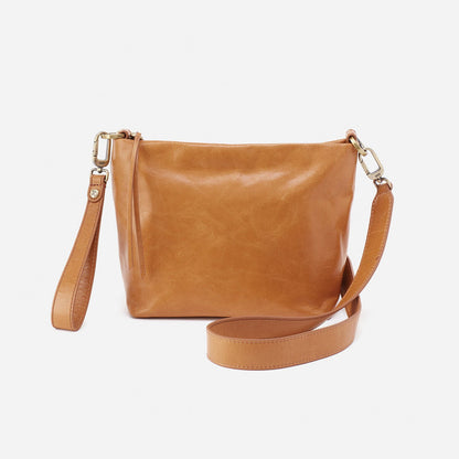 natural Ashe Crossbody with strap and wristlet draped around it on a white background.