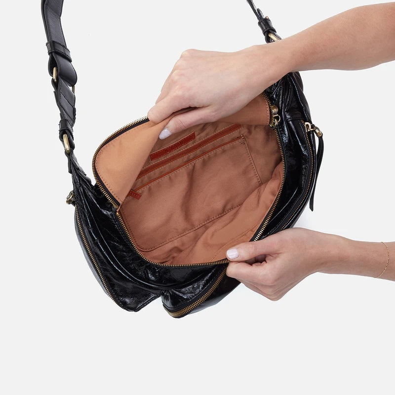 hands holding open Via Belt Bag Sling showing interior.