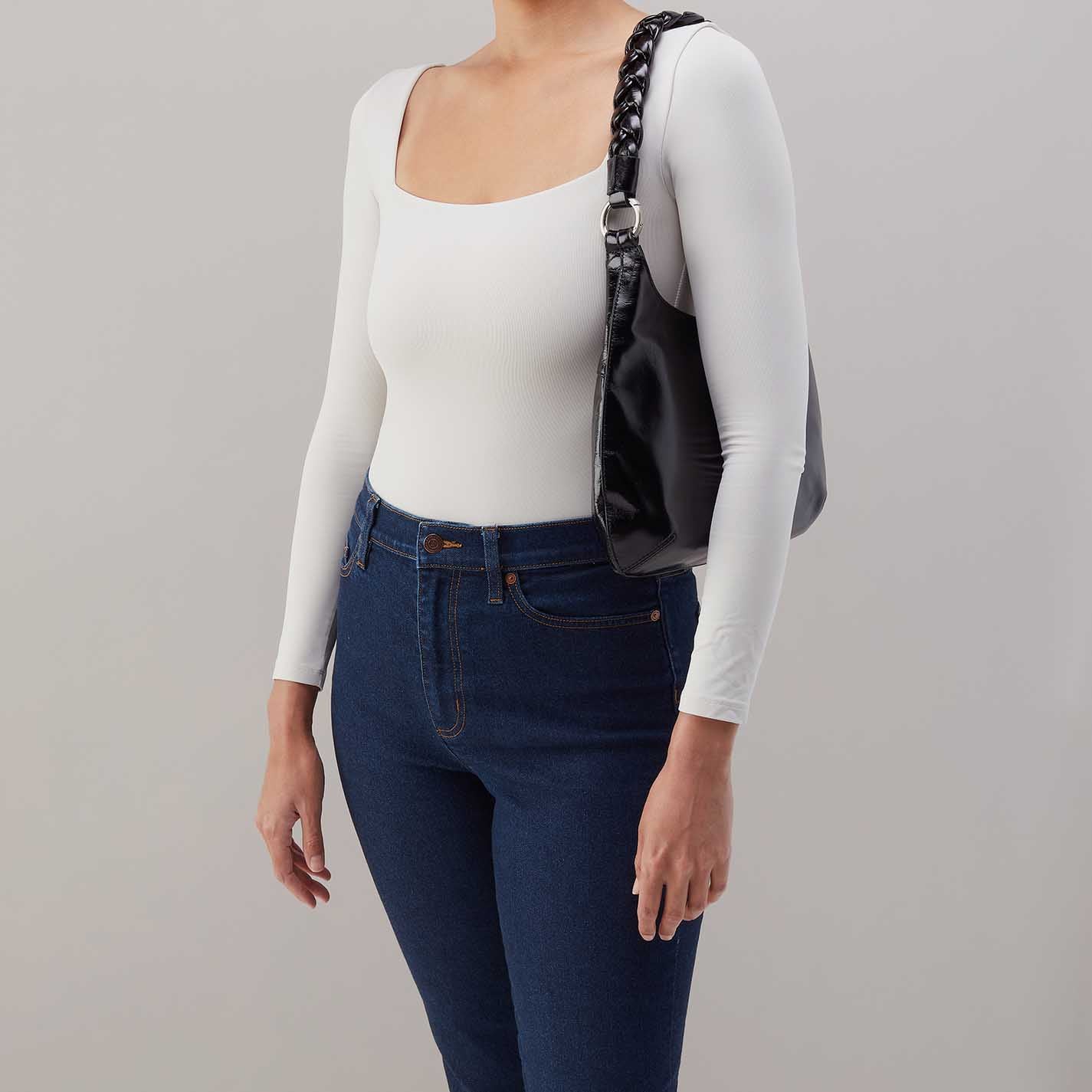 Person wearing jeans and a white top
with black Madison Shoulder Bag on the shoulder