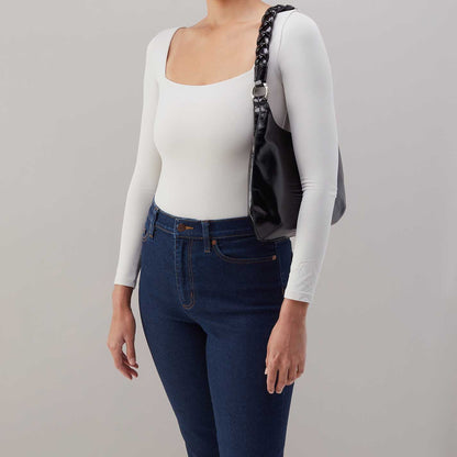 Person wearing jeans and a white top
with black Madison Shoulder Bag on the shoulder