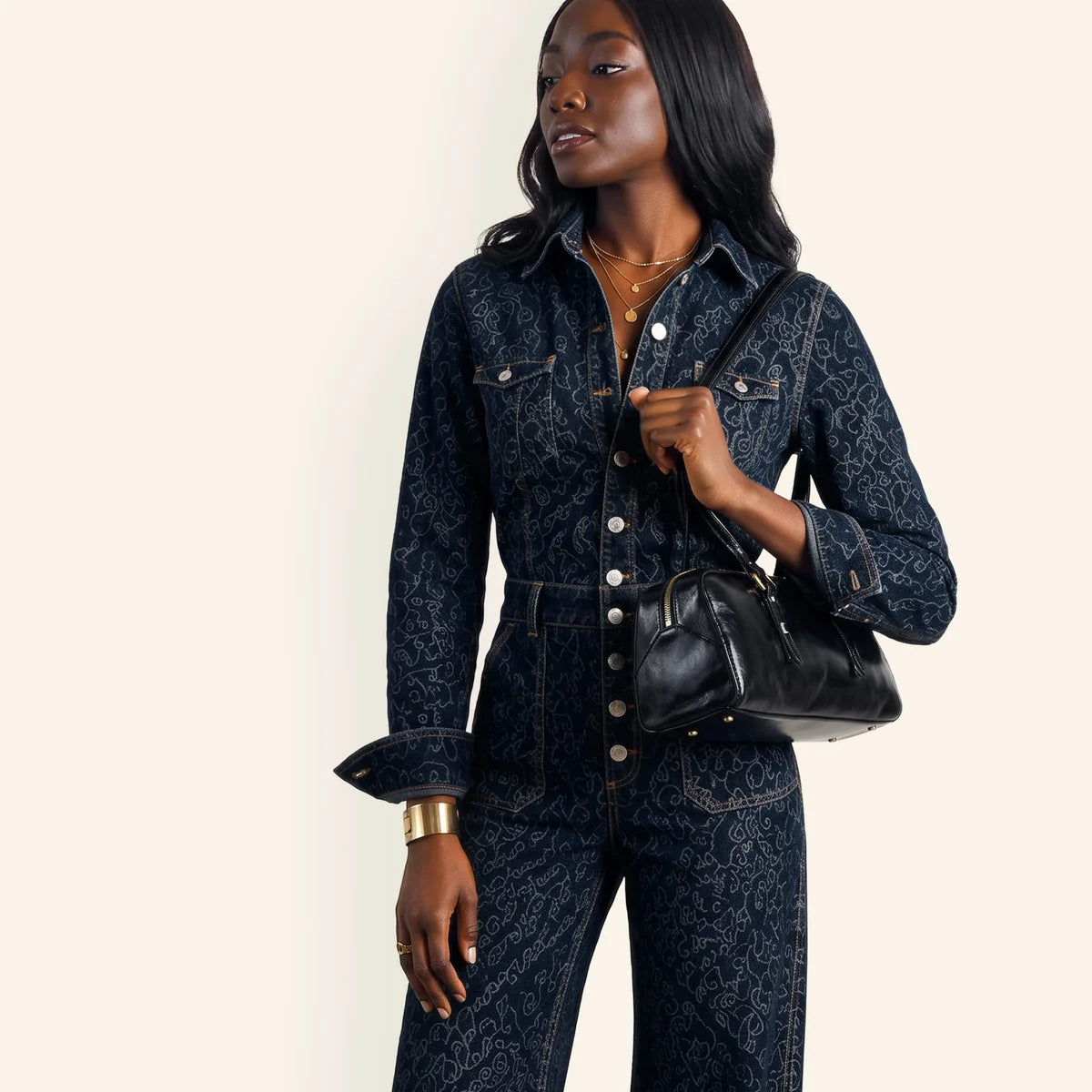 a person holding the scottie satchel in black