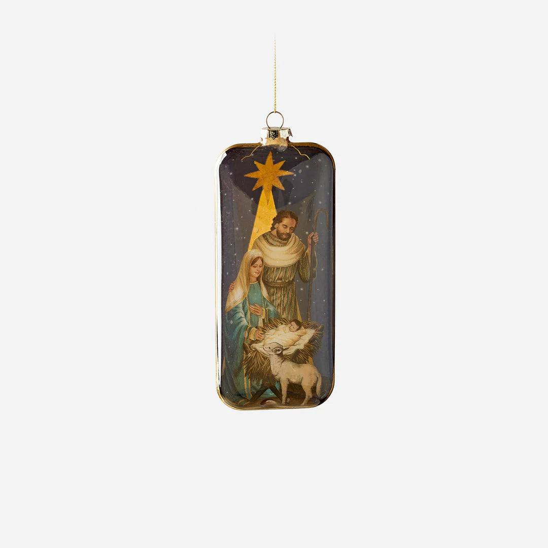 holy family ornament with image of baby jesus in manger next to a lamb, mary and joseph standing near, and a star above